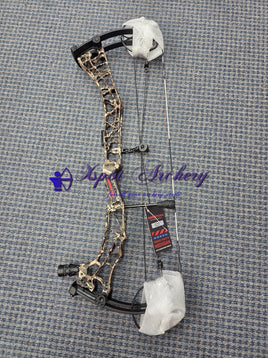 Camo compound bow with protective wrapping on a blue textured floor.”